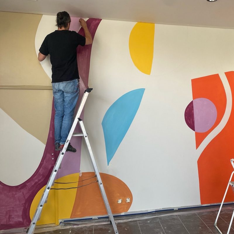 Peintre muraliste Paris réalisant une fresque artistique